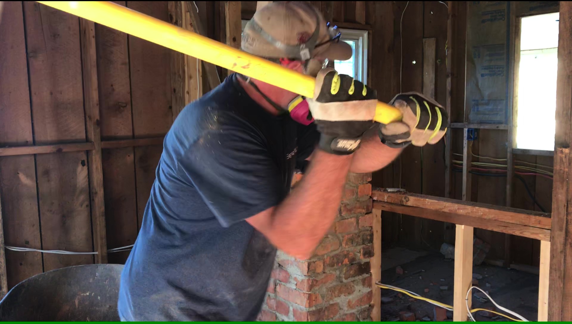 Eric Clance swinging a sledgehammer during a property renovation